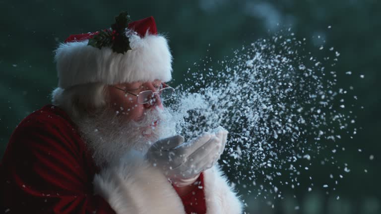 Santa Claus blowing snow from hands in slow motion