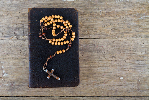 El libro de la iglesia católica liturgia y el Rosario de perlas en la mesa de madera photo