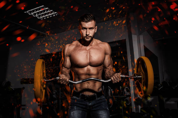 progettazione di fuoco e fiamme. uomo in palestra. muscoloso bodybuilder ragazzo facendo esercizi con bilanciere. persona forte. background sportivo. giovane atleta pronto per l'allenamento di sollevamento pesi - dumbbell weights weight training biceps femoris foto e immagini stock