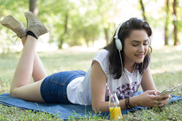 istock She enjoys while lying in the grass and listening to music 802047458