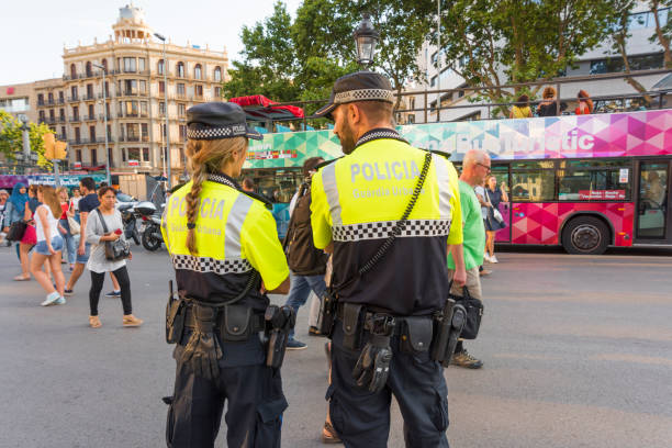 Policeman and Policewoman in Barcelona, Spain 'Barcelona, Spain- jun 1, 2017: Policeman and Policewoman standing on the street in Barcelona, Spain, observing people and doing their job police policewoman women spain stock pictures, royalty-free photos & images