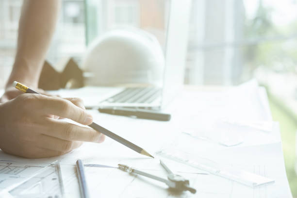 istock Architect working on real estate project at workplace. Male engineer hand working with living house blueprint at office. Business, people, construction and building concept 802124694