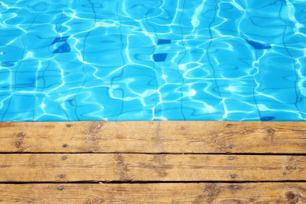 istock top view of swimming pool and wooden deck background 802149016