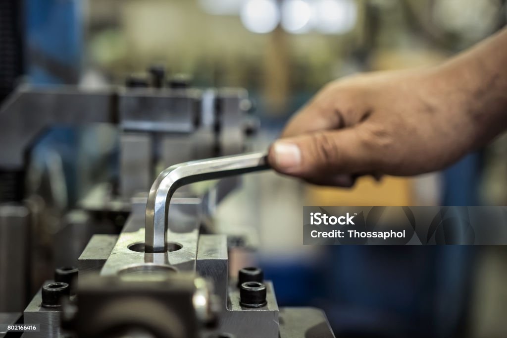 Worker is used Hexagonal screwdriver in factory Hex Wrench Stock Photo