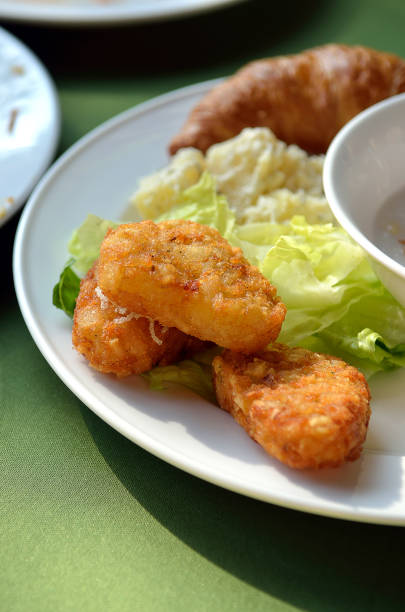 chicken nuggets and vegetable salad on a white plate
