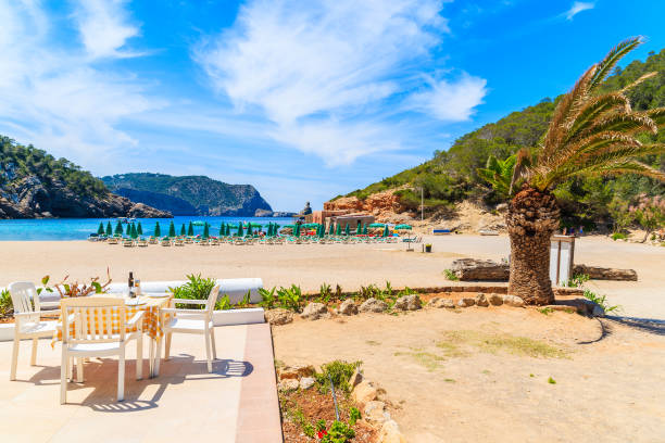 restaurant table on sunny terrace on cala benirras beach, ibiza island, spain - dining nautical vessel recreational boat europe imagens e fotografias de stock