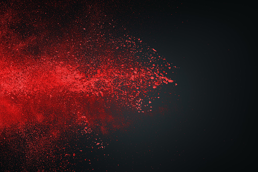 Abstract design of red powder cloud against dark background