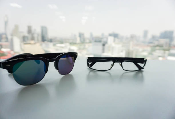 istock isolated sunglasses and modern men glasses on office desk in city backdrop 802236310
