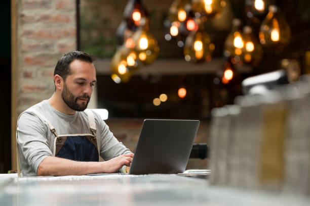 business owner doing the books at a restaurant - ceo financial advisor businessman serious imagens e fotografias de stock