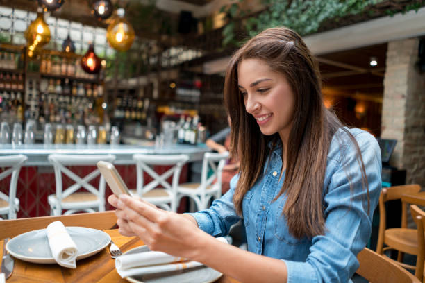 istock Woman texting on her cell phone while having a cup of coffee 802236502