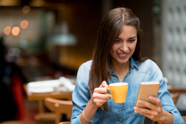 istock Woman texting on her cell phone at a cafe 802236608