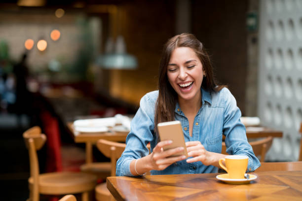 istock Woman having fun texting on her phone at a cafe 802236610