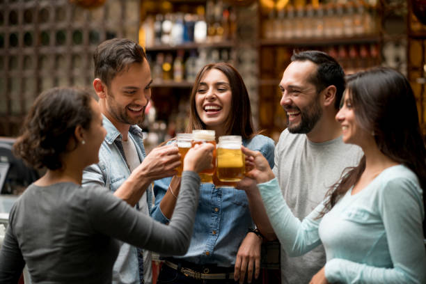 glückliche gruppe von freunde machen einen toast in einem restaurant - happy hour stock-fotos und bilder