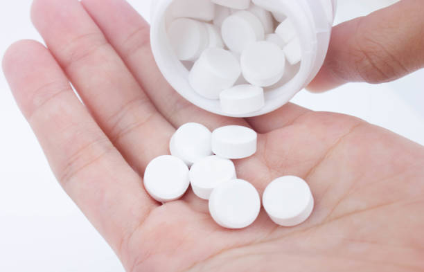istock Pouring White Medicines From A Pill Bottle Into Hand 802255730