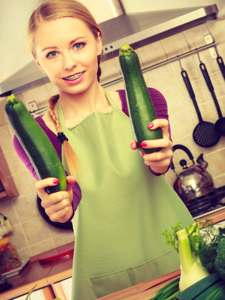 istock Woman in kitchen holds zucchini vegetable 802263766