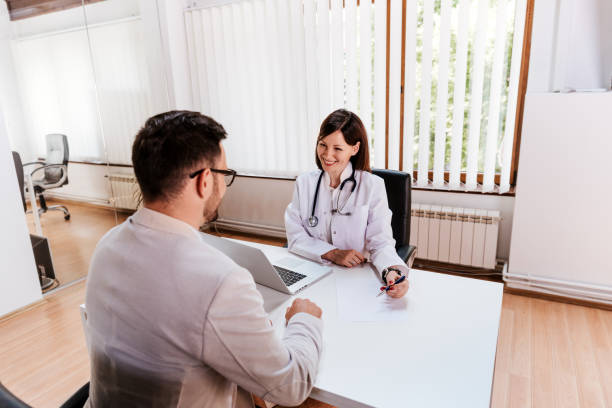 istock Doctor and patient sitting at a table talking in a office 802269832