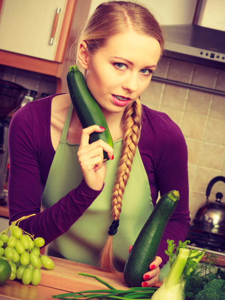 istock Woman in kitchen holds zucchini vegetable 802282054