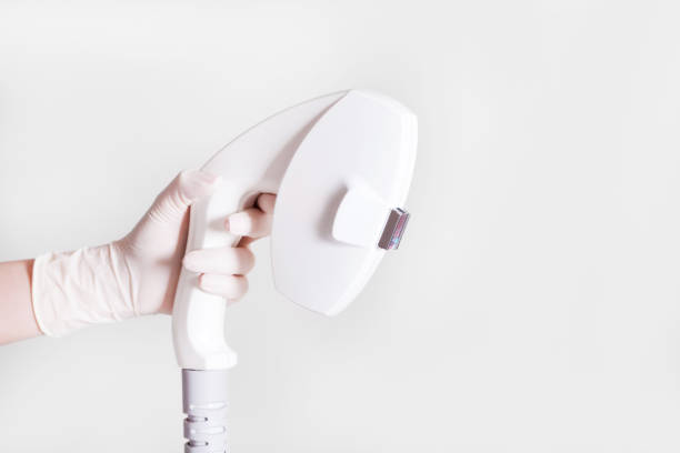 enfermera sosteniendo el dispositivo de elos guantes blancos para depilación - laser waxing human skin beauty fotografías e imágenes de stock