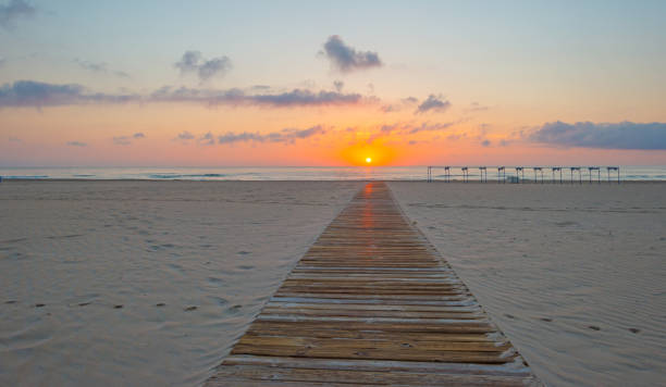 istock Sunrise over sea and sandy beach in spring 802291130