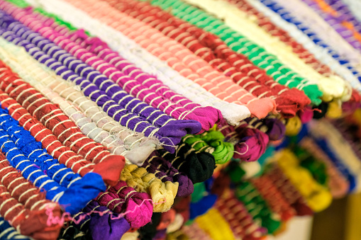 Colourful handmade rugs piled up on display at central market, South Australia