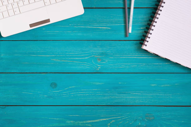 istock Laptop, notebook and pencils on wooden turquoise background with space for your text. Top view 802314574