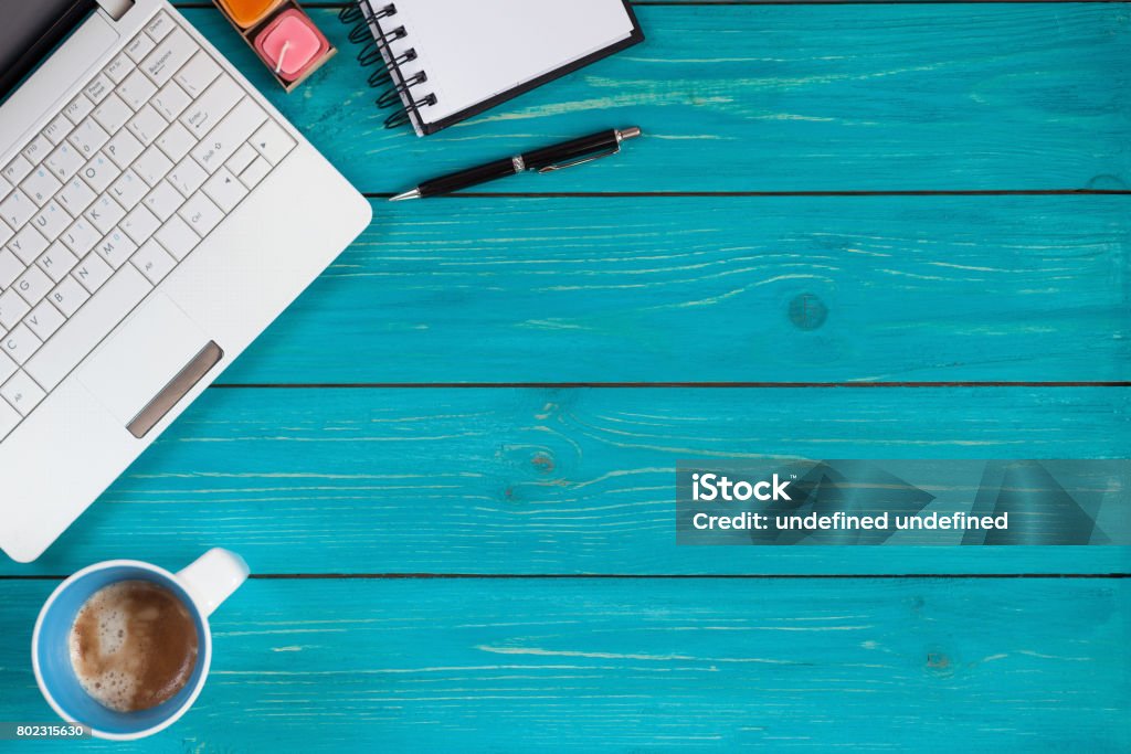 Laptop, notebook, pencil and cup of coffee on wooden background with space for text Notebook, laptop,pen and cup of coffee on rustic turquoise table with copy space. Top view Turquoise Colored Stock Photo