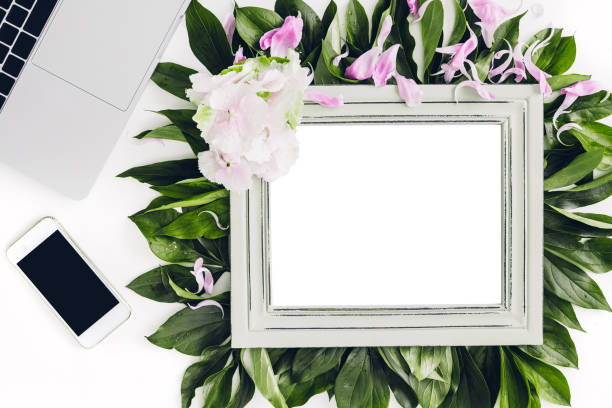 istock wooden frame decorated with flowers and leaves, laptop and phone. empty space for text 802316988