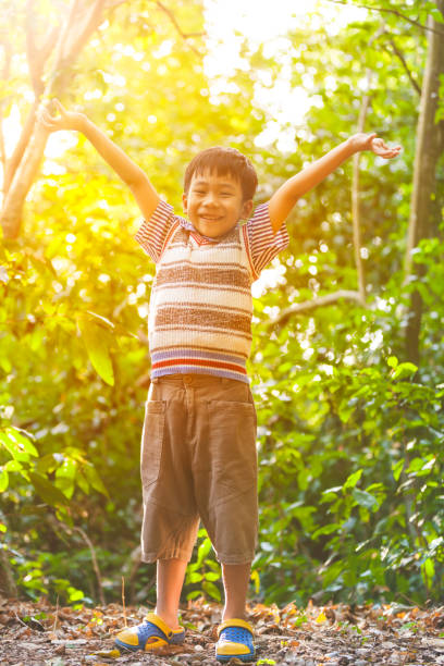 istock Happy asian boy smiling at forest. Outdoors, travel on vacation. 802317348