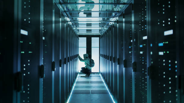istock A Hooded Hacker With Laptop Connects to Rack Server and Steals Information from Corporate Data Center. 802319208