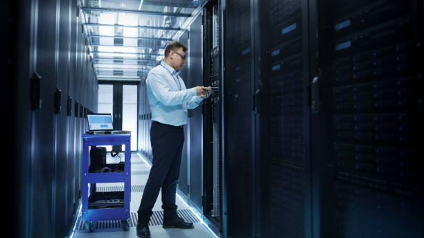 it engineer installing hard drives into working rack server. he's working in data center. - network server rack data center in a row imagens e fotografias de stock