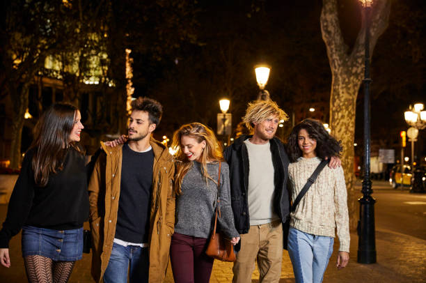 istock Multi-ethnic friends walking on sidewalk at night 802321584