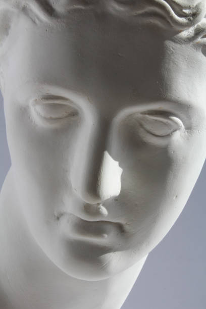 istock White plaster statue of woman face on blue grey background 802325460