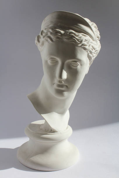 istock White plaster statue of woman head on blue grey background 802325474
