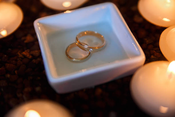 istock Wedding diamond ring with candles in the water. 802329378