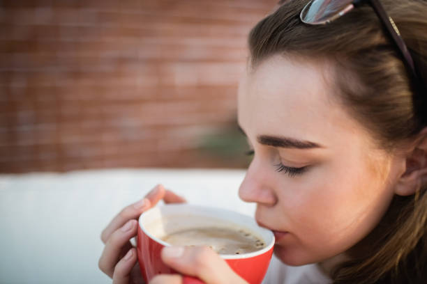 istock Pretty woman relaxing on couch with coffee 802333858