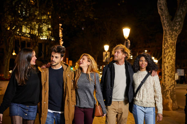 istock Cheerful friends walking on sidewalk at night 802337838