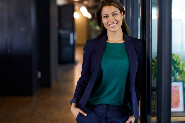 istock Female executive with hands in pockets at office 802338600