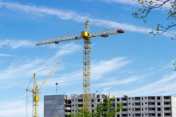istock Two tower cranes against of multi-story residential building construction 802342036