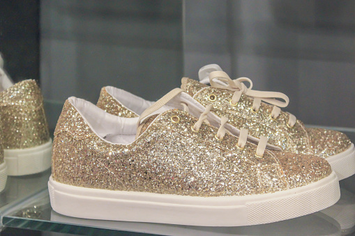 Close up a pair of gold sneaker shoes in women store
