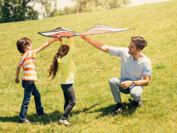 istock Father flying a kite with his children 802353048