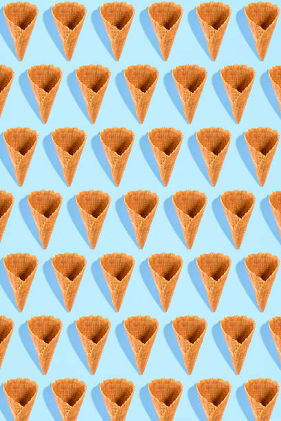 istock Sugar waffle cone for ice cream arranged in pattern on mint background. The image with copy space can be used as a background for the design of the confectionery menu 802362864