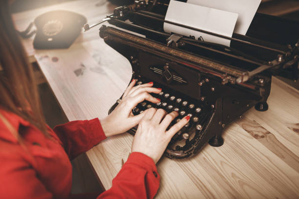 sekretärin am alten schreibmaschine mit telefon. junge frau mit schreibmaschine. business-konzepte. - author writing retro revival women stock-fotos und bilder