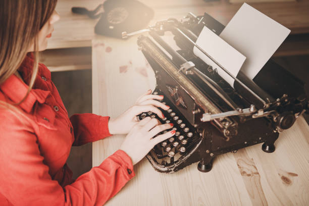 sekretarka w starej maszynie do pisania z telefonem. młoda kobieta za pomocą maszyny do pisania. koncepcje biznesowe. - author writing retro revival women zdjęcia i obrazy z banku zdjęć