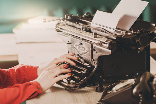 sekretarka w starej maszynie do pisania z telefonem. młoda kobieta za pomocą maszyny do pisania. koncepcje biznesowe. - author writing retro revival women zdjęcia i obrazy z banku zdjęć