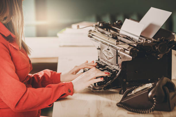 sekretarka w starej maszynie do pisania z telefonem. młoda kobieta za pomocą maszyny do pisania. koncepcje biznesowe. - author writing retro revival women zdjęcia i obrazy z banku zdjęć