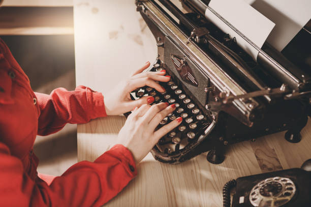 sekretarka w starej maszynie do pisania z telefonem. młoda kobieta za pomocą maszyny do pisania. koncepcje biznesowe. - author writing retro revival women zdjęcia i obrazy z banku zdjęć