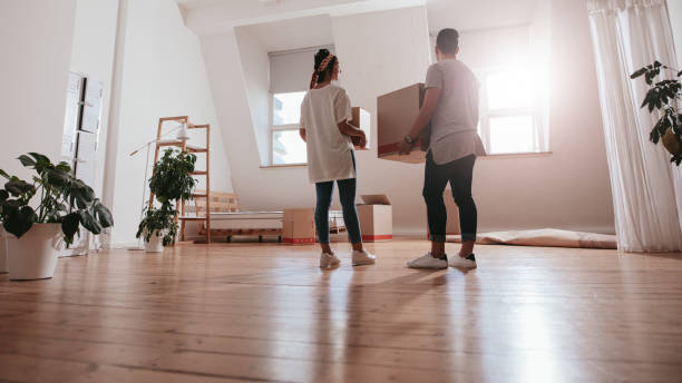 pareja joven caminando en nueva casa - women moving house men relocation fotografías e imágenes de stock