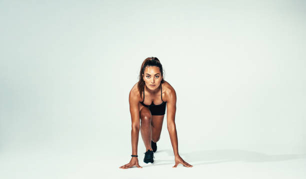athlète féminine confiant prête pour la course - athlete sport starting line muscular build photos et images de collection