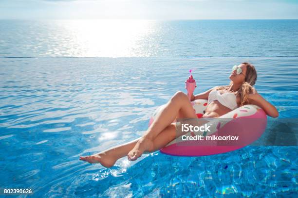 Summer Vacation Woman In Bikini On The Inflatable Mattress In The Spa Swimming Pool Stock Photo - Download Image Now