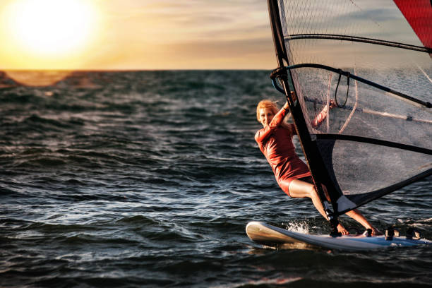 windsurfing, zabawa w oceanie, sport ekstremalny. kobiecy styl życia - windsurfing zdjęcia i obrazy z banku zdjęć